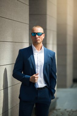 Yazlık takım elbiseli yakışıklı genç adam güneş gözlükleriyle yürüyüşe çıkmış.