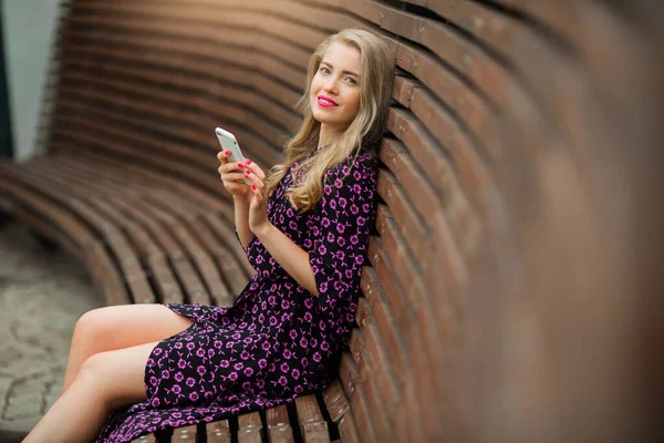 Piękna Młoda Kobieta Makijażem Letniej Sukience Siedzi Ławce Telefonem — Zdjęcie stockowe