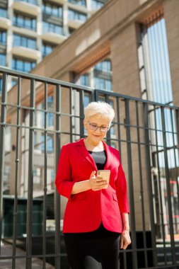 Yazın şehirde telefonu olan kısa saçlı ve gözlüklü yaşlı güzel bir kadın.