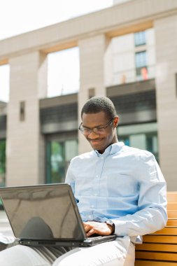 Dizüstü bilgisayarı olan yakışıklı bir Afrikalı.