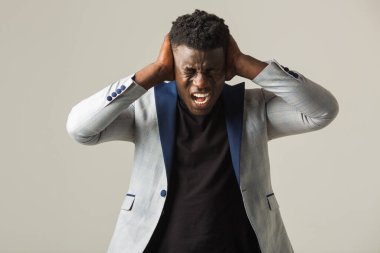 Gri arka planda ceketli yakışıklı Afrikalı bir erkek.