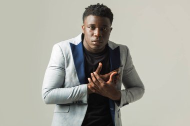 Gri arka planda ceketli yakışıklı Afrikalı bir erkek.