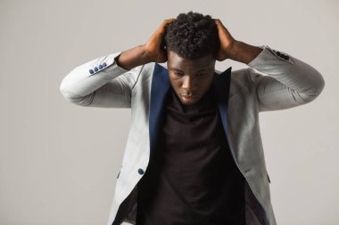 Gri arka planda ceketli yakışıklı Afrikalı bir erkek.