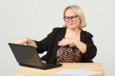 Masada gözlüklü, dizüstü bilgisayarlı beyaz arka planda güzel bir genç kadın.