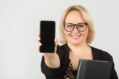 Beyaz arka planda cep telefonu olan güzel bir genç kadın.