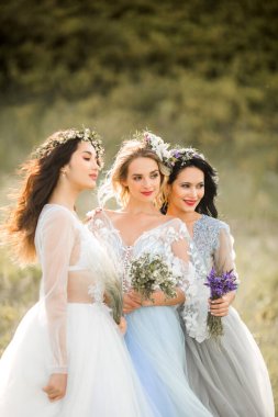 Hassas yaz elbiseleri içinde makyaj ve saç stili olan üç güzel genç bayan.