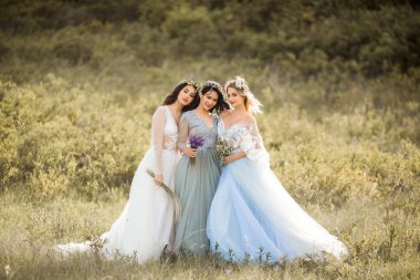 Hassas yaz elbiseleri içinde makyaj ve saç stili olan üç güzel genç bayan.