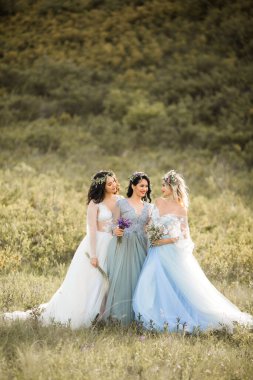 Hassas yaz elbiseleri içinde makyaj ve saç stili olan üç güzel genç bayan.