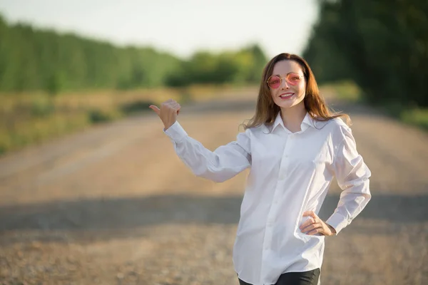 美しい若い女性が道で仲間の旅行者を待っています — ストック写真