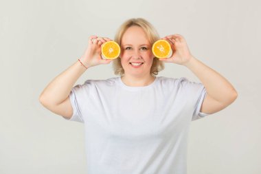 Beyaz tişörtlü, turuncu arka planda güzel, tombul bir kadın.