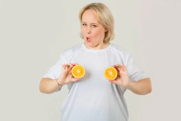 beautiful young plump woman in a white t-shirt on a white background with an orange