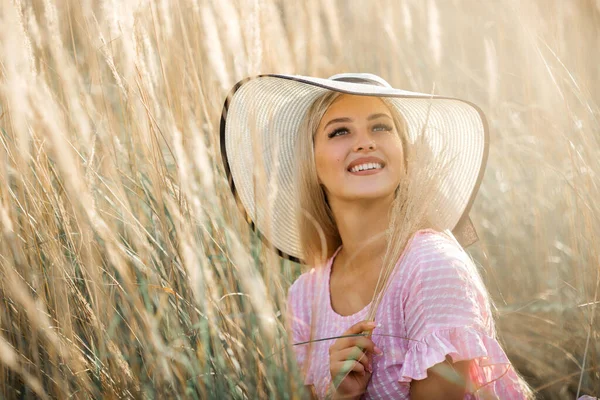 夏の畑で帽子を被った美しい若い女性が — ストック写真