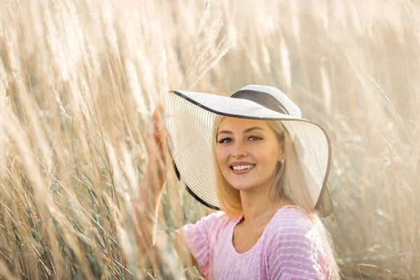 夏の畑で帽子を被った美しい若い女性が — ストック写真