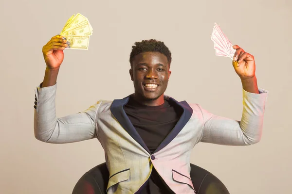 portrait of handsome african man in suit with dollars in hands