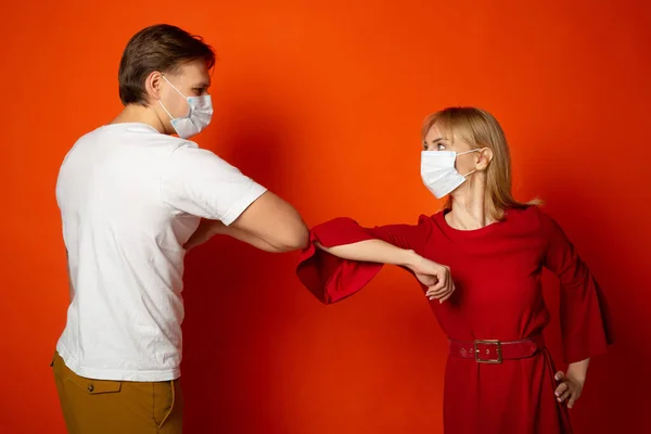 赤い背景の医療用マスクをした美しい若い夫婦と女性と男性 — ストック写真