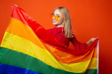 Kırmızı arka planda lgbt bayrağı olan güzel genç bir kadın.