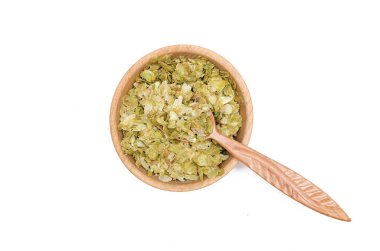 Beyaz arka plan üzerinde izole tahta kaşıkla ahşap kase toz yeşil hop kalkıyor.