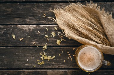 Yaşlı ahşap masa arka plan atlama ve malt ve çavdar kulaklara bardak hafif bira ile dağılmış.