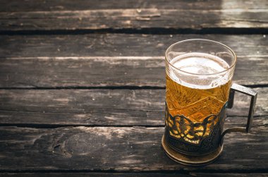 Ahşap ahşap arka plan masaya köpüklü ışık bira cam.