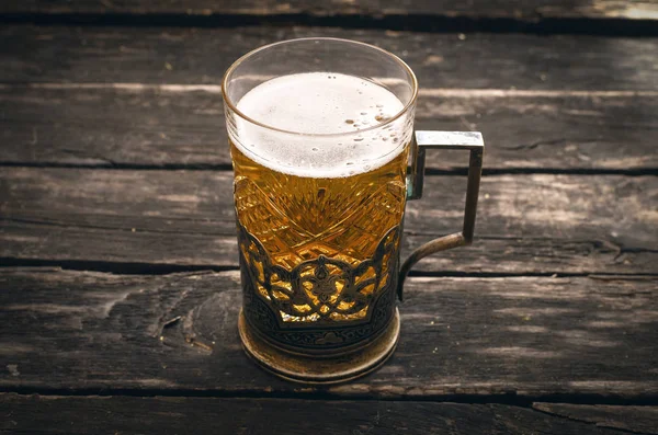 Ahşap ahşap arka plan masaya köpüklü ışık bira cam.