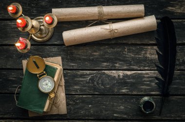 Macera ya da seyahat kavramı geçmiş. Yaşlı ahşap masa arka plan kopya alanı ile ilgili günlüğü kitap hazine avcısı, Altın Pusula, mum ve eski el yazmaları.