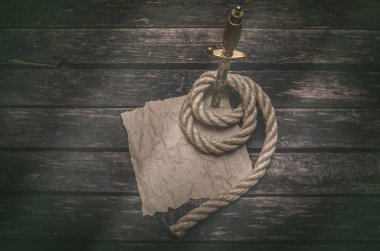Örneğin kahverengi kağıt sayfa parşömen ile kopya alanı hazine haritası için buruşuk ve hançerin bir tablo ve gemi ip itme. Maceracı hazine avcısı ya da korsan kavramı geçmiş.
