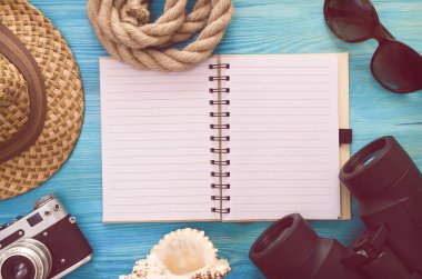 Yaz arka plan. Yapılacaklar listesi yaz. Boş boş sayfa Not defteri, dürbün, deniz kabuğu, turist şapka ve vintage fotoğraf makinesi mavi ahşap tablo.