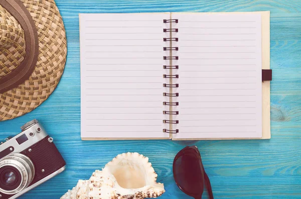 Yaz arka plan. Yapılacaklar listesi yaz. Boş boş sayfa Not defteri, deniz kabuğu, şapka ve vintage fotoğraf makinesi mavi ahşap tablo.