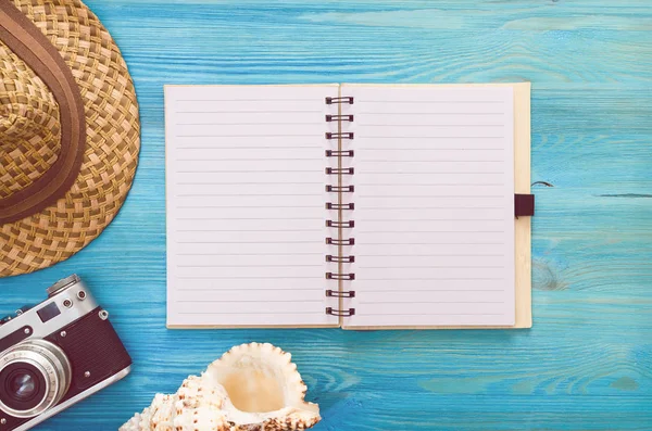 Yaz arka plan. Yapılacaklar listesi yaz. Boş boş sayfa Not defteri, deniz kabuğu, turist şapka ve vintage fotoğraf makinesi mavi ahşap tablo.