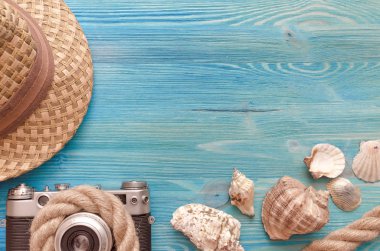 Yaz tatil arka plan kopya alanı ile. Şapka, fotoğraf makinesi, ip ve kabukları mavi ahşap masa arka plan üzerinde.