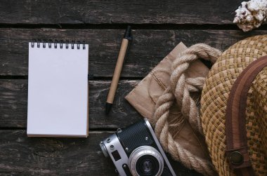 Turist veya maceracı Not defteri günlüğü kitap. Yapılacaklar listesi için. Not defteri, fotoğraf makinesi, ip, şapka ve seashell vintage tablo arka plan üzerinde.