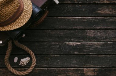 Retro yaz deniz tatil arka plan. Vintage çanta, dürbün, şapka, gemi halatı ve kopya alanı ile eski ahşap masa arka plan üzerinde deniz kabuğu.