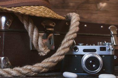 Retro yaz deniz tatil arka plan. Vintage çanta, ip, film fotoğraf makinesi, şapka ve çakıl turist masada. Önden görünüm, yakın çekim fotoğraf.
