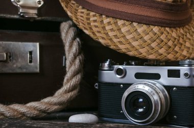 Retro yaz deniz tatil arka plan. Vintage çanta, ip, film fotoğraf makinesi, şapka ve çakıl turist masada. Önden görünüm, yakın çekim fotoğraf.