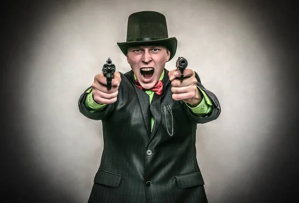 The spy. Secret service. Angry Detecive agent holds pistol gun in his hands aiming and attack. Retro wicked gangster isolated on white background.