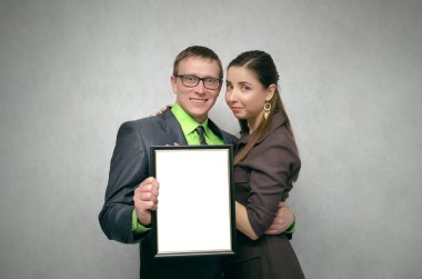 Mutlu memnun genç çift çift kopya alanı boş diploma sertifikayla elinde tutuyor. En iyi aile yıl kavramının.