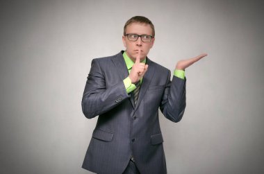 Meraklı iş adamı dikkatle üzerinde izole gri arka plan dinler. Sırlarını anlatmaya.