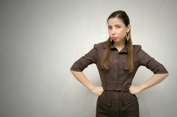 Dissatisfied annoyed girl isolated on gray background with copy space. Displeased boss woman. Wrathful teacher concept.