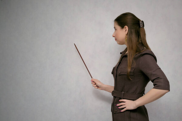 Business project presentation. Teacher or financial advisor or student with school pointer explains lesson theme isolated on gray background with copy space. 