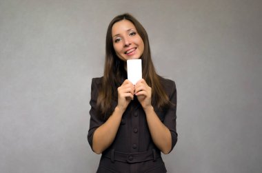 Elinde boş bir tutan mutlu gülümseyen iş kadın kart kopya alanı ile ziyaret edin. Bize ulaşın.