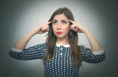 Dalgın kadın düşünme ve gri arka plan üzerinde izole bir sorunu çözmeye çalışın. Depresyon meditative hüzünlü kız.