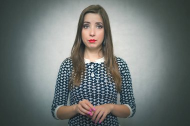 Dalgın mütevazı kadın. Gri arka plan üzerinde izole suçlu kız utanıyor.