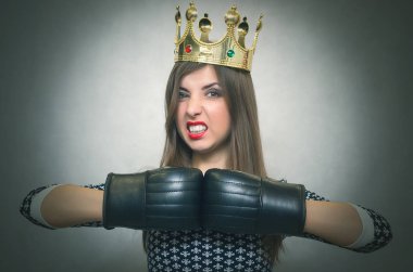 Altın taç başında ve boks eldivenleri ile kızgın kendine güvenen kadın. Kötü ruh kavramı ukala kız. Memnun karısı. Kadın maç. Kadın güzellik yarışması kavramı. Kadın rekabet.