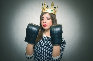Altın taç başında ve boks eldivenleri ile kızgın kendine güvenen kadın. Kötü ruh kavramı ukala kız. Memnun karısı. Kadın maç. Kadın güzellik yarışması kavramı. Kadın rekabet.