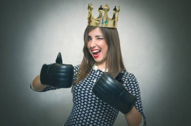 Altın taç başında ve bir başparmak göstermek yukarıya bir boks eldivenleri ile mutlu bir kadın. Kadın maç. Kadınlar güzellik Şampiyonası. Güzellik Yarışması Birincisi.