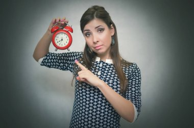 Eller kırmızı alarm masa saati içinde tutarak ve zaman onun parmağı tarafından gösterilen sıkı patron kadın. İş veya okul geç uyarı kavramı. Azarlama kilise fazla uyumak.