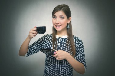 Kahve molası. Kahve zamanı. Öğle yemeği molası. Bir fincan kahve gri arka plan üzerinde izole elinde tutan mutlu gülümseyen kadın.