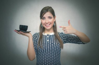 Kahve molası. Kahve zamanı. Öğle yemeği molası. Bir fincan kahve gri arka plan üzerinde izole elinde tutan mutlu gülümseyen kadın.