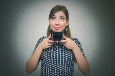 Kahve molası. Kahve zamanı. Öğle yemeği molası. Holding mutlu gülümseyen kadın kahve eller ve gri arka plan üzerinde izole kokuyor.