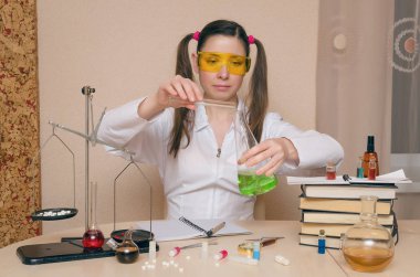 Duygusal öğrenci kız Kimya ders üzerinde sıvı tüp bebek gösterilmektedir. Eczacı veya eczacı kadın. Bilimsel deney arka plan. Kimyasal laboratuvar kavram genç Stajyer.